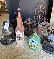 Group photo of the 8 decorative items including birdhouses, birdcages, and lanterns displayed on carpet.