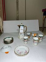 Full set of 13 pieces including coffee pot, cups, saucers, and plates displayed on white surface