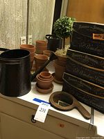 Overall view of the flower pots, watering can, faux topiary, decorative boxes, hand mirror, and flower frog.