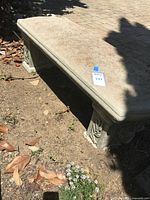 Full side view of bench on ground showing overall shape and support structure