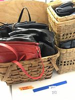Various handbags and a woven picnic basket shown together in two stacked wicker baskets. Includes red and black leather handbags visible on top.
