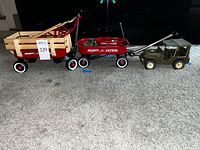 Three wagons and a Tonka jeep lined up on carpet floor. Shows lot contents and relative size.