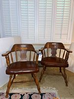 Two Windsor-style wooden armchairs side-by-side, showing overall condition and design.