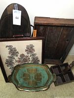 Photo of assorted vintage wood trays including oval Florentine painted tray, antique dough bowl, framed textile, compartment tray, and small wooden box.