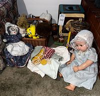 Overall view of set including baby doll, wooden toys, crocheted clothes, plush toy