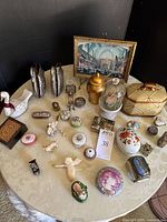 Wide overview of all trinket boxes and figurines displayed on round table