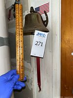 Bell height measurement showing about 6 inches tall next to a ruler held by a gloved hand.