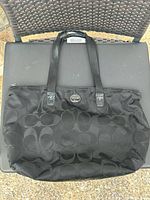 Front view of black Coach nylon Signature C tote