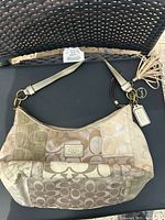 Front view of Coach patchwork Signature C hobo bag showing exterior panels, strap and hangtag