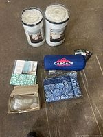 Group shot of all items: two furniture protectors, Cascade blanket, teal fabric, glass shades box, blue paisley fabric