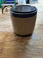 Full view of cylindrical cat ottoman showing fabric exterior and black perforated lid