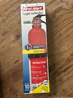 Front of boxed First Alert fire extinguisher showing branding and warranty