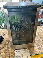 Front view of GE Profile wine chiller with glass door and manual visible