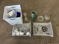 Overview of lot showing plates, thermos, glassware bins and crystal vase