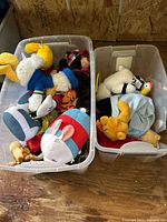 Two clear bins filled with assorted plush toys
