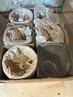 Box with six compartments holding tumblers wrapped in tissue