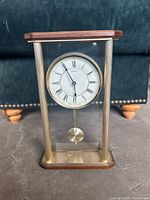 Front view of Seiko glass-case mantel clock showing dial and pendulum
