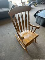 Front view of wooden rocking chair showing seat, arms and runners