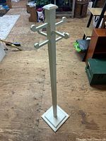 Full view of white wooden coat rack standing upright