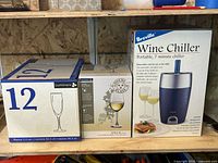 Three boxed items: Breville wine chiller, Luminarc champagne flutes, Luminarc Villa wine glasses
