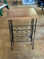Front view of wine rack side table showing wood top and metal frame