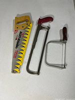 All three saws laid out: hand saw in sleeve, hacksaw, coping saw