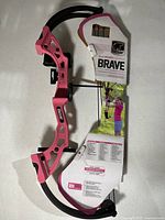 Full view of Bear Archery Brave compound bow attached to packaging