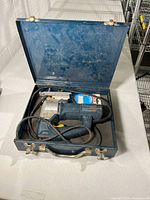 Jigsaw inside blue Bosch case showing power cord and tool