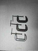 All three metal C-clamps side by side