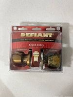 Front view of packaged Defiant brass keyed-entry lockset