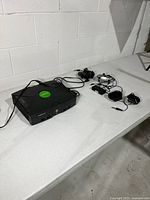 Xbox console with power and AV cables on table
