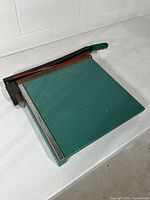 Top view showing full paper cutter with grid surface, ruler guide and blade arm