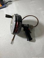 Full view of RIDGID Kwik-Spin drain cleaner showing handle, drum, extended spring cable