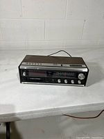 Front view showing clock display, 8-track slot, tuner and controls