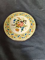 Closed view of vintage Stratton compact powder case showing detailed floral design on the lid.