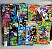 Photograph showing a collection of 10 comic books including Marvel's Spider-Man titles, DC's Superman and Batman, Legion of Super-Heroes, and two Dragonlance graphic novels.