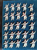 Photo of 25 identical Quebec Winter Carnival mascot lapel pins displayed on blue felt, showing front details and enamel colors