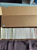 Open cardboard box filled with approximately 800 hockey cards. Cards are vertically stacked in tight rows and appear mostly uniform in size with various colored edges visible along the pack edges.