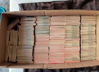 Top-down photo of a large cardboard box filled with many stacks of hockey cards packed vertically, showing the large volume of cards included in the lot.