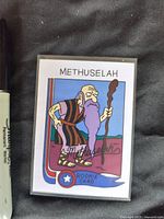 Front photo of the Methuselah rookie card showing cartoon biblical character with staff, purple beard, and 'Rookie Card' emblem.