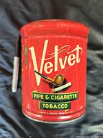 Front view of red Velvet Pipe and Cigarette Tobacco tin with pipe illustration and brand logo
