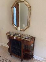 Image showing the full cabinet with wire mesh door, side shelves with glass backs, glass decor on top and octagonal wall mirror above