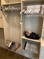 Photo showing a combination of multiple types of clothes hangers and a stack of winter gloves on a shelf.