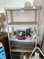 Full view of one Keter ABS 5-shelf rack loaded with multiple items including plastic bins, tools, and hardware.