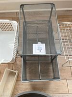 Gray metal mesh two-tier under sink organizer, one basket slot has a divider inside