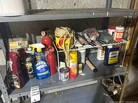 Wide view of items on metal shelving including automotive chemicals, insect spray, paint brushes, rope, and cleaning supplies