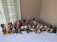 Overview of the assorted miniature figurines displayed on a table showing various styles and materials