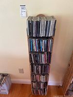 Full view of approximately 60-80 CDs in cases arranged vertically in a narrow wicker CD rack