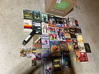 Full overview of all VHS tapes and cases laid out on the floor and some still in a cardboard box