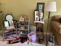Image showing a group of household decor items including a green chair, books, a shelving unit, floor lamp, framed art, a decorative keyboard toy, and other miscellaneous items.
